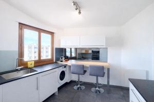 a kitchen with a sink and two bar stools at M046 T3 cosy 2 chambres et balcon in Ambilly