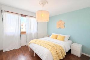 a bedroom with a white bed with a yellow blanket at M046 T3 cosy 2 chambres et balcon in Ambilly