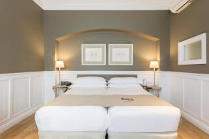 two beds in a room with two lamps at Hotel Granvia in Barcelona +52 photos