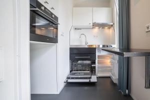 a kitchen with white cabinets and a sink at CampingHotel Renesse in Renesse +19 photos