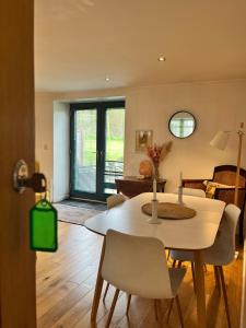 a living room with a white table and chairs at Crymlyn barn in Llanwrda +16 photos