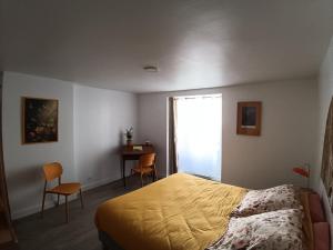 a bedroom with a bed and a desk and a window at la demeure des songes in Josselin +2 photos