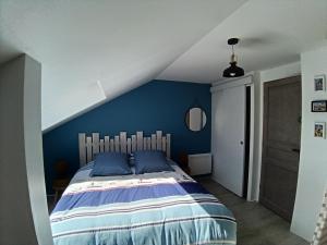 a bedroom with a bed with a blue wall at la demeure des songes in Josselin