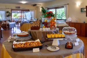 a table with several different types of food on it at iH Hotels Le Zagare Resort in Villasimius
