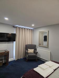 a room with a bed and a chair and a mirror at Darlington Arms by the airport - Free parking - Bar & Food in Redhill