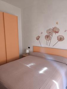 a bedroom with a bed with flowers on the wall at Albergo La Maria in Fiumaretta di Ameglia