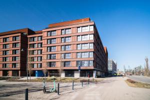 a large brick building on the side of a street at Prime Apartments Gdańsk in Gdańsk