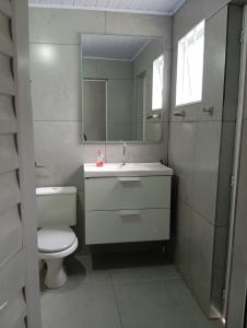 a bathroom with a sink and a toilet and a mirror at Quarto casal in Itaqui +16 photos