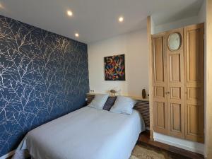 a bedroom with a bed and a blue wall at Le loft - hypercentre de Tours in Tours