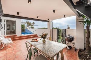 a dining room with a table and chairs and a grill at Beach Villa Cristina by HHBCN in Castelldefels
