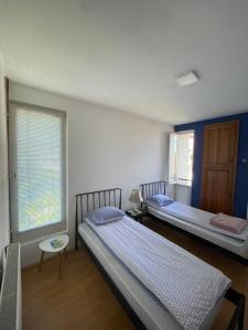 two beds in a room with blue and white walls at Sky Hostel in Peje