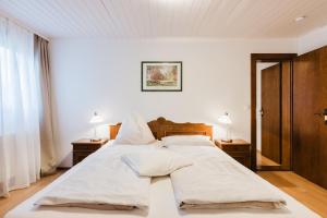 ein Schlafzimmer mit einem großen weißen Bett und zwei Lampen in der Unterkunft Trippolthof in Prebl