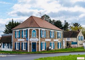 an old brick building with blue shutters on a street at Relais Saint-Laurent - Chevreuse in Chevreuse