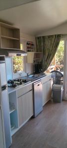 a kitchen with a sink and a stove at Camping Fontisson in Châteauneuf-de-Gadagne