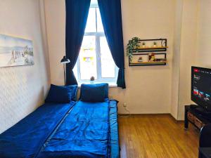 a bedroom with a blue bed in front of a window at Studio, Fireplace, Super location, Free Parking in Tallinn +8 photos