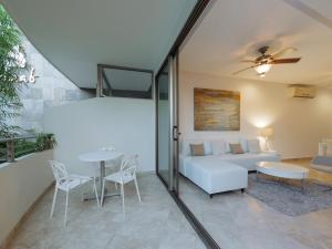 sala de estar con sofá y mesa en Charming 2BR condo in quiet surroundings by Happy Address, en Playa del Carmen