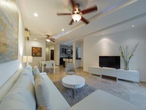 sala de estar con sofá y TV de pantalla plana en Charming 2BR condo in quiet surroundings by Happy Address, en Playa del Carmen