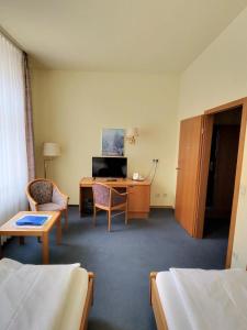 a hotel room with a desk and a bed at Hotel Drei Rosen in Borna