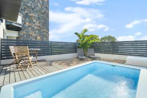 a swimming pool on a balcony with a table and chairs at Golden Bloom - High-End Duplex w Private Pool in Rivière Noire