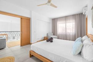 a bedroom with a large bed with a ceiling fan at Golden Bloom - High-End Duplex w Private Pool in Rivière Noire +13 photos