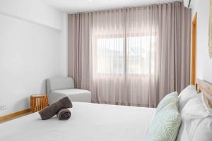 a bedroom with a bed and a chair and a window at Golden Bloom - High-End Duplex w Private Pool in Rivière Noire