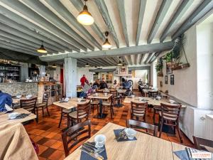 a restaurant with wooden tables and chairs and people at Relais Saint-Laurent - Chevreuse in Chevreuse