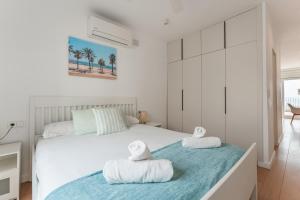 a bedroom with a bed with towels on it at Beach Villa Cristina by HHBCN in Castelldefels +56 photos
