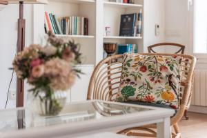 a wicker chair with a pillow on a table at Beach Villa Cristina by HHBCN in Castelldefels