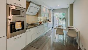 a kitchen with a counter with a sink and a microwave at Alta de Faro in Faro