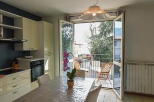a kitchen with a table and chairs and a balcony at Casa Vacanza Ninfea in Paratico