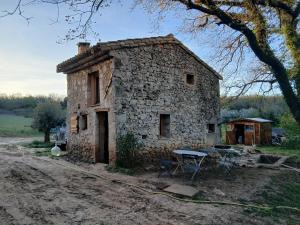 an old stone house with a table in front of it at Les Bergeries d Orkan in Châteauneuf-du-Rhône