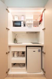 a small kitchen with a sink and a refrigerator at Seven Paddington in London