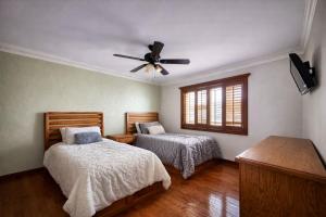 a bedroom with two beds and a ceiling fan at Arroyos del Paraíso Residencial Suite C in Manuel F. Martínez