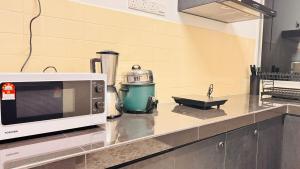 a microwave sitting on a counter in a kitchen at uncommon homestay in Klang
