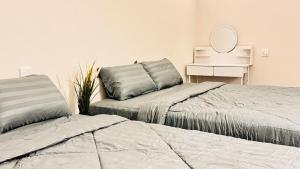 two beds in a room with a mirror and a table at uncommon homestay in Klang +64 photos
