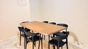 a wooden table with black chairs around it at uncommon homestay in Klang