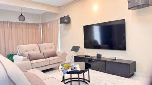 a living room with a couch and a flat screen tv at uncommon homestay in Klang