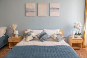 a bedroom with a bed with pillows and pictures on the wall at Actinia Accommodation in Alghero