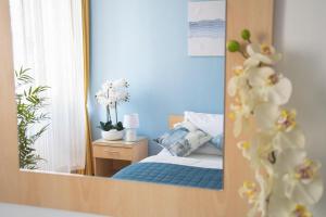 a reflection of a bedroom with a bed in a mirror at Actinia Accommodation in Alghero