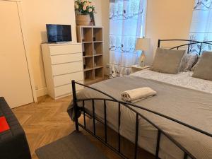 a bedroom with a bed with a dresser and a television at Central Reading Cozy Spacious Room in Reading