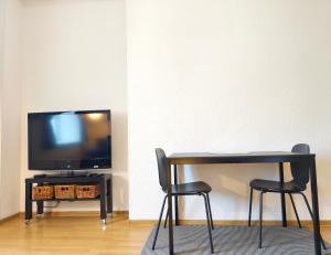 a black table with two chairs and a television at Studio, Fireplace, Super location, Free Parking in Tallinn