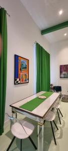 a table and chairs in a room with green curtains at La Dimora del Cardinale in Naples
