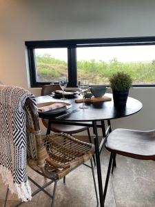 a dining room table and chairs with a window at Efri Torfa - Luxury in Nature - Peaceful & Cosy in Kirkjubæjarklaustur