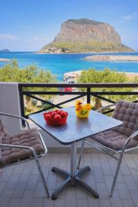 Ein Tisch und Stühle auf einem Balkon mit Blick auf das Meer in der Unterkunft AGNANTIO in Monemvasia