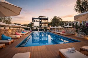 a hotel pool with lounge chairs and a building at Hotel Memai Suites in Ksamil