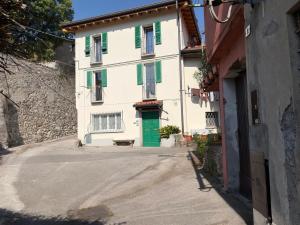 ein Gebäude mit einer grünen Tür an einer Straße in der Unterkunft Gerenzone Bridge-Air conditioning in Lecco