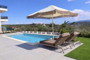 a swimming pool with two chairs and an umbrella at Aria Vista Chalkidiki in Agios Nikolaos