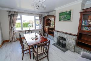 a dining room with a table and a fireplace at Castle View in Oughterard
