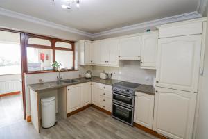 a kitchen with white cabinets and a black stove top oven at Castle View in Oughterard