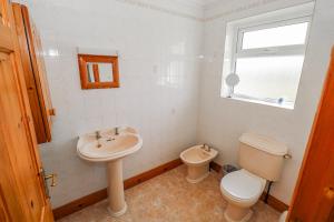 a bathroom with a sink and a toilet and a window at Castle View in Oughterard +19 photos